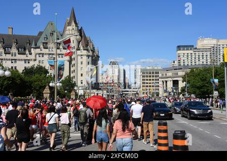 Ottawa, Kanada - 1. Juli 2024: Eine große Gruppe von Menschen geht in Richtung Rideau Street auf einem Teil der Wellington Street, der während des Canada Day, einem jährlichen gesetzlichen Feiertag, der den Jahrestag der kanadischen Konföderation am 1. Juli 1867 feiert, für Fußgänger gesperrt ist Stockfoto