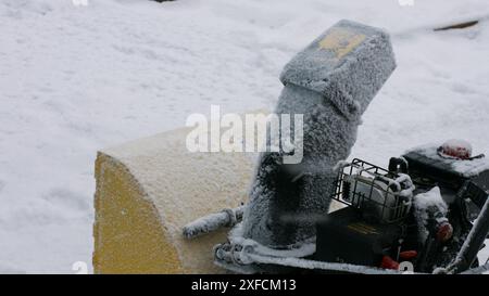 Schneefräse. Der Mensch reinigt die Straße vom Schnee. System zur Schneereinigung. Stockfoto