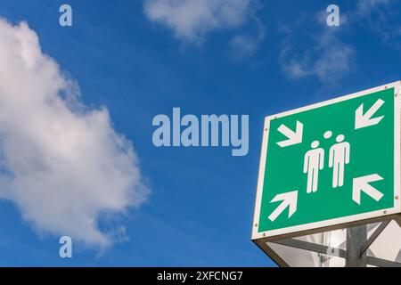 Grünes Schild für Sammelstelle vor blauem Himmel mit Wolken im Hintergrund Stockfoto