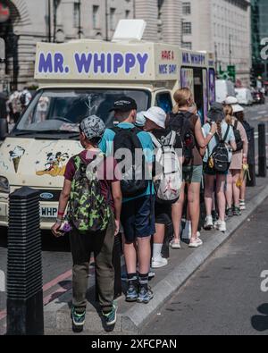 Touristen stehen an einem seltenen sonnigen Tag an der Westminster Bridge in London an, um Eis zu kaufen. Stockfoto