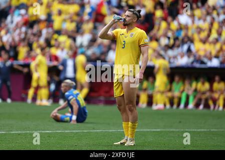 München, Deutschland - 17. Juni 2024: Radu Dragusin aus Rumänien (#3) trinkt Wasser während des Gruppenspiels der UEFA EURO 2024 Rumänien gegen Ukraine in der Münchner Fußball-Arena Stockfoto