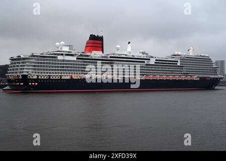 Kreuzfahrtschiff Queen Anne läuft erstmals Hamburg an. 2. Juli gegen 6,30 Uhr lief das Kreuzfahrtschiff Queen Anne erstmals den Hamburger Hafen an. Begleitet war der Cruise Liner traditionell vom Feuerlöschboot Branddirektor Westphal, welches mit Wasserfontänen beim Erstanlauf das Kreuzfahrtschiff begrüßte. Um kurz vor 7 Uhr machte die Flottenschwester der Queen Mary II am Cruise Center Steinwerder fest. Das Schiff der Reederei Cunard Line, die zu Carnival gehört, wurde erst vor einem Monat am 3. Juni 2024 im Rahmen der British Isles Festival Voyage in Liverpool getauft. Taufpaten sind di Stockfoto