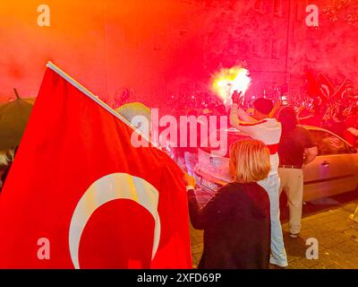 Türkische Fans machen in Bruchsal nach EM-Viertelfinaleinzug die Nacht zum Tag: Hunderte Türkei-Fans belagern Straße vor dem Bahnhof in Bruchsal und feiern den türkischen Sieg über Österreich lautstarke Siegesfeier mit Bengalos, Fahnen und Musik nach dem überraschenden Einzug der türkischen Nationalmannschaft ins Viertelfinale der UEFA EM 2024 sind die türkischen Fans in Deutschland kaum noch zu halten. In Bruchsal brach nach dem Schlusspfiff wortwörtlich die Hölle los und die Bahnhofstraße verwandelte sich wie beim Einzug ins Achtelfinale in einer riesigen Partyzone. Hunderte Türkei-Anhänger ve Stockfoto