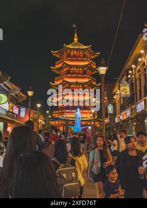 Jakarta, Indonesien - 11. Mai 2024. Ein Foto von einer hell erleuchteten Pagode, die in warmes Licht getaucht ist, und Guanyin-Göttin-Statue, die vor einer Tradition steht Stockfoto