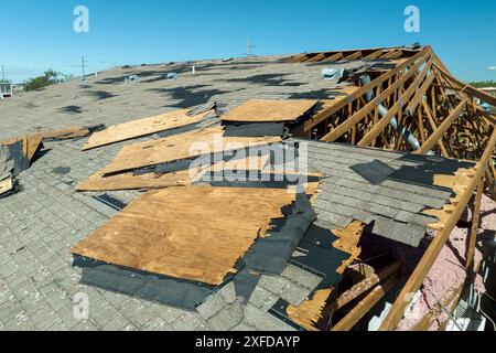 Das Dach ist kaputt und muss repariert werden. Durch Wind beschädigtes Hausdach mit fehlenden Asphaltschindeln nach Hurrikan Ian in Florida Stockfoto