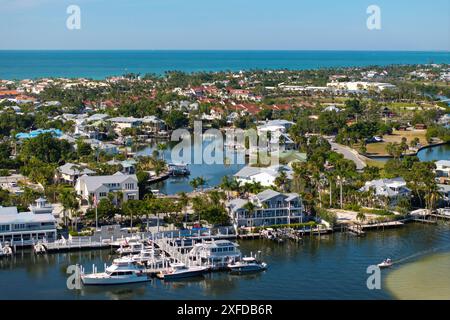 Wohlhabendes Viertel in der kleinen Stadt Boca Grande, Florida mit teuren Häusern am Wasser zwischen grünen Palmen. Entwicklung von Premium-Wohnungen in den USA Stockfoto