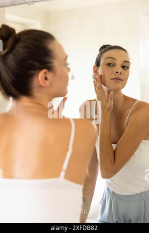 Hautpflege anwenden, junge Frau im Spiegel im Badezimmer zu Hause Stockfoto