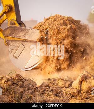 Nahaufnahme des Baggers auf der Baustelle. Baggerlader für Erd- und Bauarbeiten. Aushubarbeiten bei der Arbeit. Schwere Maschinen Stockfoto
