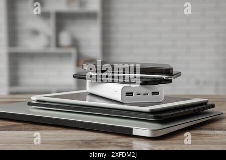 Stapel moderner Gadgets auf Holztisch in der Werkstatt Stockfoto