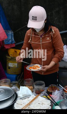 Ein Frühstücksverkäufer auf dem Bàn Thạch Fischmarkt in der Nähe von Hoi an, Vietnam. Stockfoto