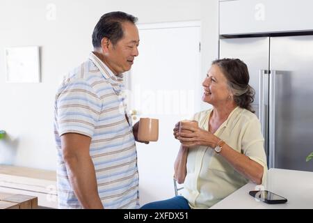 Genießen Sie Kaffee und Unterhaltung, Seniorenpaar in moderner Küche Stockfoto