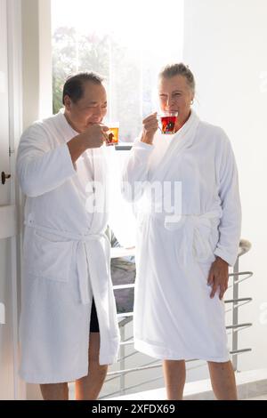 Ein älteres Paar in Bademänteln trinkt Tee und genießt den gemeinsamen Morgen Stockfoto