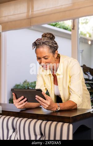 Zu Hause stehen, reife Frau mit Tablet und lächelnd Stockfoto