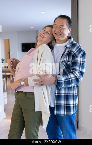 Seniorenpaar tanzen und lächeln zusammen in gemütlicher Atmosphäre Stockfoto