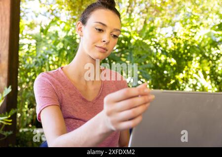 Mit Laptop, junge Frau, die von zu Hause aus im Freien arbeitet Stockfoto