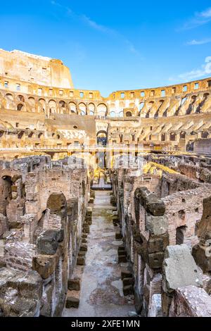 Ein Blick auf das Kolosseum in Rom bei Sonnenuntergang und Blick hinunter in die Arena. Das antike Amphitheater ist in warmes Licht getaucht und bietet Besuchern die Möglichkeit, die historische Stätte zu erkunden. Stockfoto