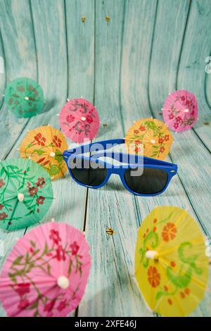 Kindersonnenbrille und mehrfarbige Cocktailschirme in Zahnpistolen Stockfoto