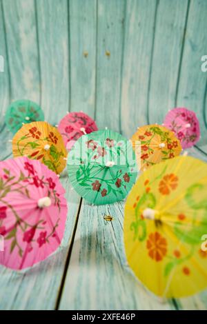 Mehrfarbige Cocktailschirme mit Blumenmuster auf Holz Stockfoto