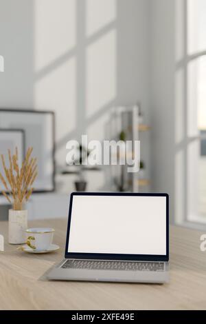 Ein Nahbild eines Laptops mit einem Mockup auf weißem Bildschirm, einer Keramikvase mit Pampasgras und einer Kaffeetasse auf einem Holztisch in minimalistischem Stil Stockfoto