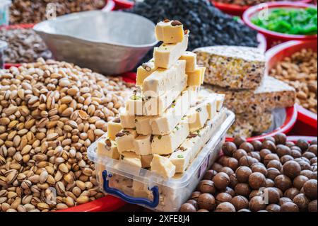 Usbekische Halva, orientalische Süßigkeiten, getrocknete Früchte und verschiedene Nusssorten auf dem asiatischen usbekischen Basar auf der Theke Stockfoto