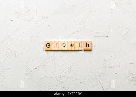 Wachstumswort auf Holzblock geschrieben. Wachstumstext auf dem Tisch, Konzept. Stockfoto