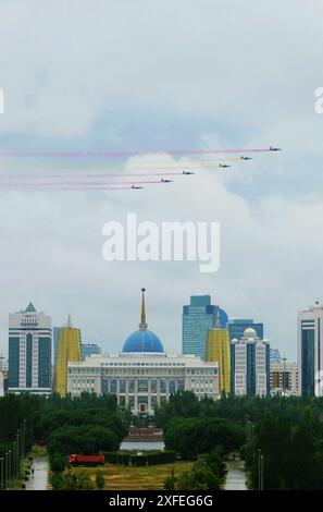 (240703) -- ASTANA, 3. Juli 2024 (Xinhua) -- kasachische Kampfflugzeuge bemalen den Himmel mit farbigen Rauchspuren, während der kasachische Präsident Kassym-Jomart Tokayev am 3. Juli 2024 eine Begrüßungszeremonie für den Besuch des chinesischen Präsidenten Xi Jinping in Astana, Kasachstan, veranstaltet. Eine Gruppe von sechs Jets, die über den Präsidentenpalast flogen, hinterließ farbige Rauchspuren in Rot und Gelb, Farben der chinesischen Nationalflagge. XI ist auf einem Staatsbesuch in Kasachstan und wird hier an der 24. Sitzung des Rates der Staatschefs der Shanghai Cooperation Organization (SCO) teilnehmen. (Xinhua/Wang Jianhua) Stockfoto