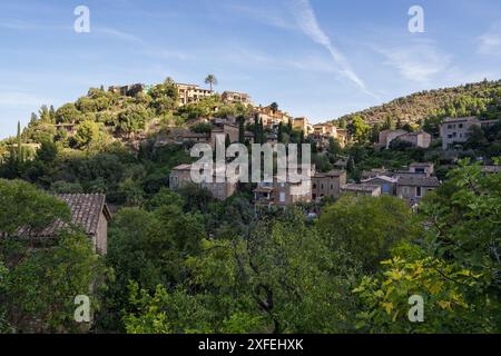 Atemberaubende Stadtlandschaft der kleinen Küstenort Deia auf Mallorca, Spanien. Traditionelle Häuser in Terrassen auf den Hügeln umgeben von grünen Bäumen entfernt Stockfoto