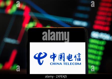 China. Juni 2024. In dieser Abbildung ist das Logo des chinesischen staatlichen Telekommunikationsunternehmens China Telecom auf einem Smartphone mit einem wirtschaftlichen Börsenindex im Hintergrund zu sehen. Quelle: SOPA Images Limited/Alamy Live News Stockfoto