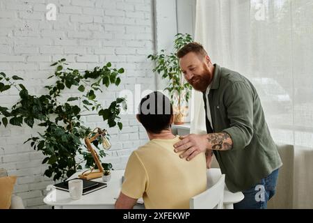 Ein bärtiger Mann in einem grünen Hemd spricht mit einem Mann in einem gelben Hemd, ein schwules Paar, das gute Zeit miteinander verbringt. Stockfoto