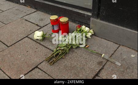 Blumen liegen vor der Hamburger Sparkasse am Jungfernstieg, daneben stehen Kerzen. Am Dienstagmorgen war es vor der Filiale der Haspa in der Innenstadt zu einem schweren Autounfall gekommen. Ein 18 Jahre alter Fahrer hatte die Kontrolle über seinen Mercedes AMG verloren und war mit hoher Geschwindigkeit in ein anderes Fahrzeug gefahren. Vier Menschen wurden bei dem Unfall verletzt, ein 39-jähriger Mann erlag wenige Stunden nach dem Unfall im Krankenhaus seinen schweren Verletzungen. Altstadt Hamburg *** Blumen liegen vor der Hamburger Sparkasse am Jungfernstieg, daneben stehen Kerzen Stockfoto