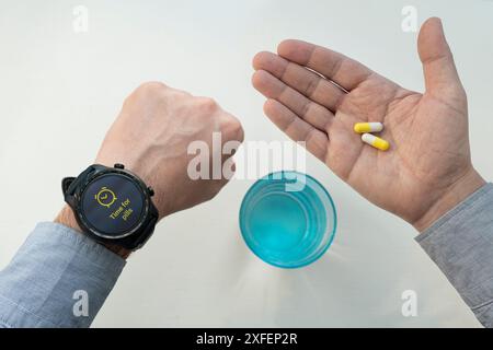 Zeit, Pillen für den Menschen zu nehmen. Time for Tablets ist eine Inschrift auf dem Bildschirm einer Smart Watch. Das Konzept der rechtzeitigen Medikamentenaufnahme. Behandlung ti Stockfoto