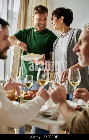 Ein schwules Paar genießt ein Essen mit seiner Familie zu Hause. Stockfoto