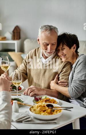 Erwachsene Eltern essen mit ihrem Sohn und seinem Partner bei einem gemütlichen Abendessen zu Hause. Stockfoto