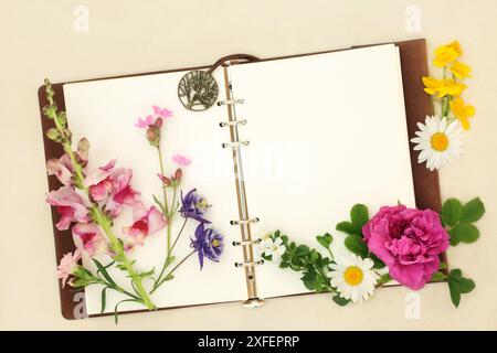 Blumen Kräuter und Wildblumen mit Notizbuch. Wird in der Aromatherapie und Naturheilkunde verwendet. Blütenessenzen für alternative Heilmittel auf Hanfpapier Stockfoto