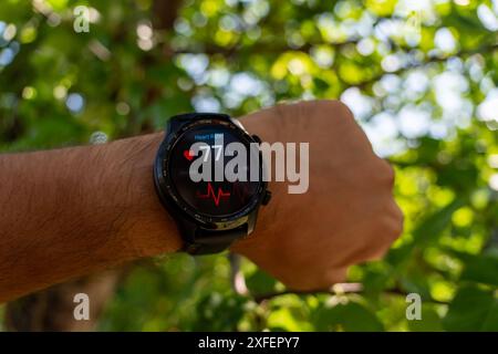 Nahaufnahme des Smart Watch Health Tracker mit der auf dem Bildschirm angezeigten Herzfrequenz. Modernes, elegantes und innovatives tragbares Gerät. Sportler überprüft sein Hörvermögen Stockfoto