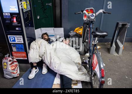 Obdachlose Drogenabhängige, rauer Schlaf unter Santander Leihfahrräder, bekannt als Boris Bikes, vor der Waterloo Station, London, England, Großbritannien Stockfoto