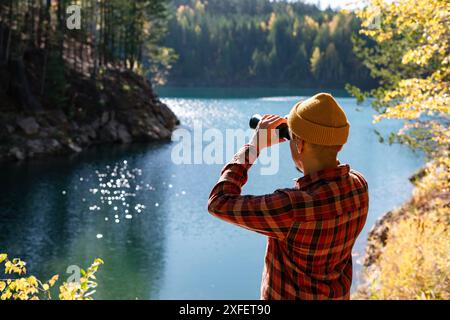 Rückansicht des Menschen mit Fernglas auf Vögel am See im Herbst Vogelbeobachtung, Zoologie, Ökologie Forschung in der Natur, Beobachtung von Tieren Ornitho Stockfoto