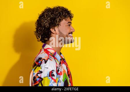 Profilporträt des netten jungen Mannes Blick leer Raum tragen Hemd isoliert auf gelbem Hintergrund Stockfoto
