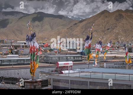 Bajiaojie, Lhasa, Tibet, China - 21. Mai 2022: Blick von oben auf die Flaggen auf dem Dach eines Gebäudes vor blauem Himmel mit Fenster und weißer Wand Stockfoto