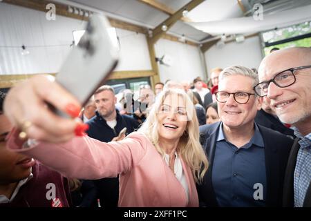 Die ehemalige dänische Premierministerin Helle Thorning-Schmidt macht ein Selfie mit dem Vorsitzenden der Labour Party, Sir Keir Starmer, und ihrem Ehemann, Stephen Kinnock (ganz rechts) auf der West Regwm Farm in Whitland, Carmarthenshire, nachdem Starmer am letzten Tag der Wahlkampagne für die morgigen Parlamentswahlen die Anhänger angesprochen hatte. Bilddatum: Mittwoch, 3. Juli 2024. Stockfoto