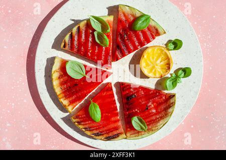 Gegrillte Wassermelonenscheiben mit Zitrone und Basilikum. Sommerdessert Stockfoto