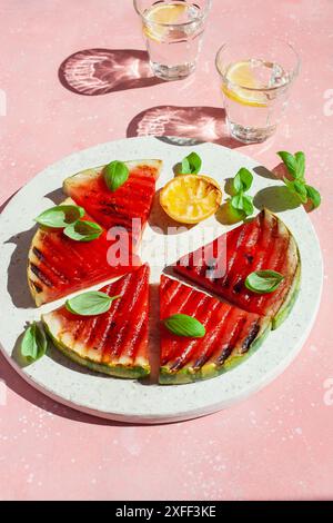Gegrillte Wassermelonenscheiben mit Zitrone und Basilikum. Sommerdessert Stockfoto