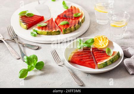 Gegrillte Wassermelonenscheiben mit Zitrone und Basilikum. Sommerdessert Stockfoto