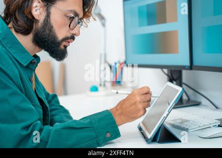 Mann, der mit einem digitalen Tablet im modernen Büro arbeitet. Stockfoto