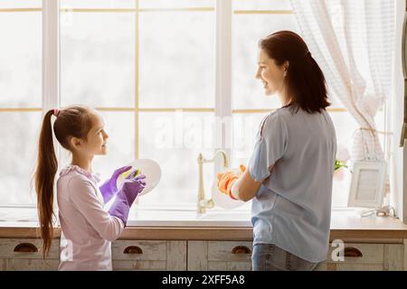 Mutter und Tochter waschen Geschirr zusammen in der Küche am Fenster Stockfoto
