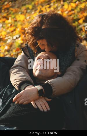 Glückliches verheiratetes Paar über 50 Jahre alt, umarmt sich im Herbst an einem warmen sonnigen Tag, verbringt einen gemeinsamen Tag. Stockfoto