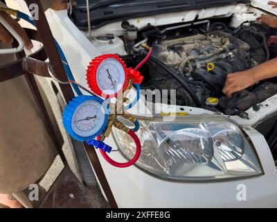 Mechaniker prüfen AC-Druckmessgeräte für Kfz-Anwendungen mit Werkzeugen Stockfoto