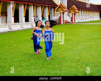 Kinder spazieren durch Pha That Luang oder Phra Chedi Lokachulamanee in Vientiane, Laos. Stockfoto