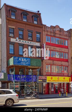 NYC Chinatown: 9 und 7 East Broadway, flache Backsteinhäuser. Nummer 9 (hinter dem Gerüst) beherbergt Büros und Geschäfte; Nummer 7 ist ein buddhistischer Tempel. Stockfoto