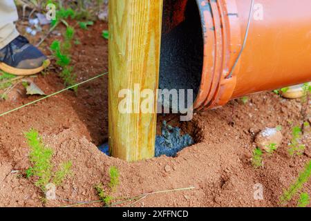 Betongießen neu installierter Holzzäunhölzer Stockfoto